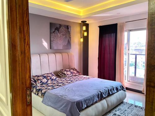 a bedroom with a large bed with a window at 2BHK Apartment Perfect for Families & Groups in Rawalpindi