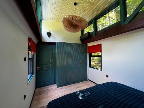 ein Schlafzimmer mit einem Bett und einer grünen Tür in der Unterkunft 0'Bama - Unique Upcycled Tiny House in Selgas