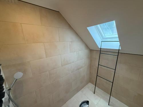 a bathroom with a shower with a ladder and a window at EJ Apartments in Gartow