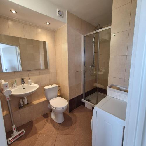 a bathroom with a toilet and a sink and a shower at Modern Studio Nagórki in Olsztyn