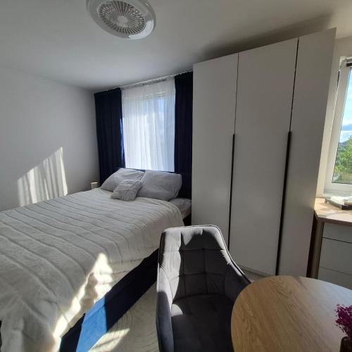 a bedroom with a bed and a table and a window at Modern Studio Nagórki in Olsztyn