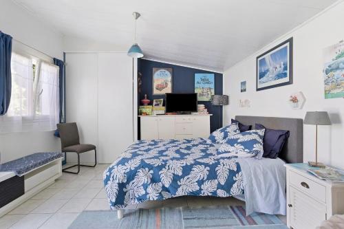 a bedroom with a bed with a blue and white comforter at Chambre d'hôte Lajarrieleduc in La Jarrie
