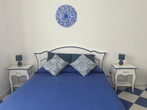 a bedroom with a blue bed with two tables at Dimora Patrizia in Scario