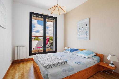 a bedroom with a bed and a large window at Les 2 tours La Rochelle in La Rochelle