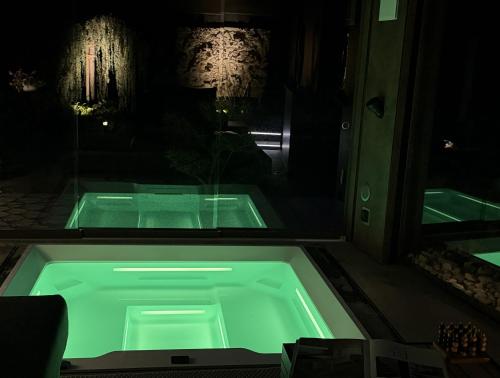 a green bath tub in a room with a window at ALPENGARTEN EIGENTHAL - Private Wellness Retreat in Eigenthal
