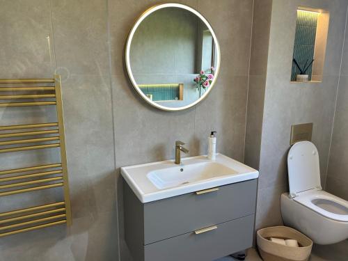 a bathroom with a sink and a toilet and a mirror at Murreigh Beag Waterville in Waterville