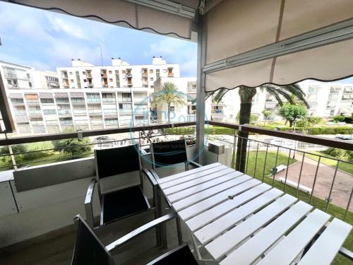 a balcony with a table and chairs and a large window at Beach Formentor salou in Salou