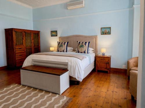 a bedroom with a large bed and a wooden floor at Oakdene Guest House in Oudtshoorn