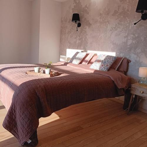 a bedroom with a large bed with pink blankets and pillows at Gîte Entre Semois et Forêt in Chiny