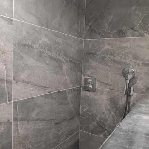 a bathroom with a shower with a stone wall at Gîte Entre Semois et Forêt in Chiny