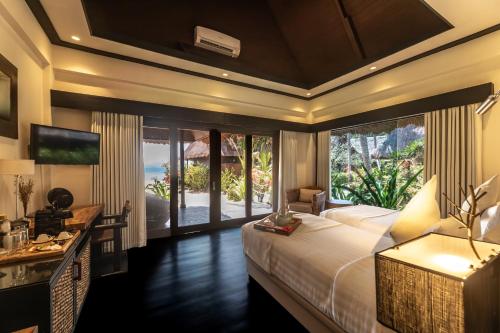 a bedroom with a bed and a desk and a window at Cauayan Boutique Private Island - formerly Cauayan Island Resort in El Nido