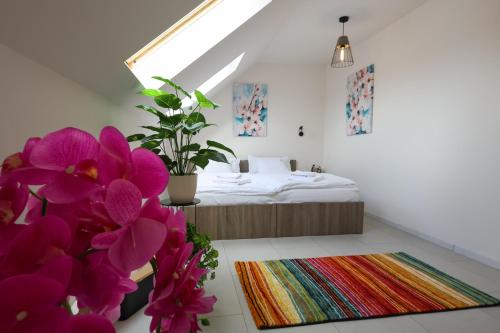 a room with a bed and purple flowers in it at MADISON RANCH in Szabolcsveresmart