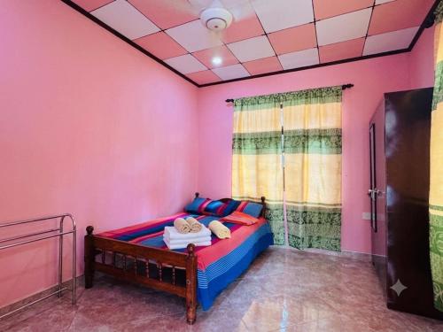 a bedroom with a bed in a room with pink walls at DIMORA Bologngna in Chilaw
