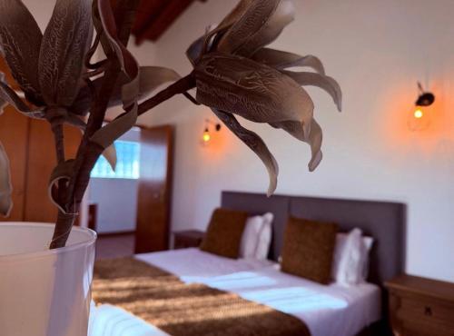 a room with two beds and a vase with a plant at Azores Quinta do Segredo in Ponta Delgada