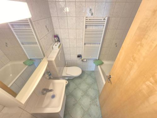 a bathroom with a toilet and a sink and a tub at FeWo Aquileia Scuol, Gratisparken, Terrasse, Wifi, flexible Zimmerwahl, Familien in Scuol