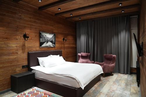 a bedroom with a bed and two chairs at Fayz Mount Residence in Chimgan