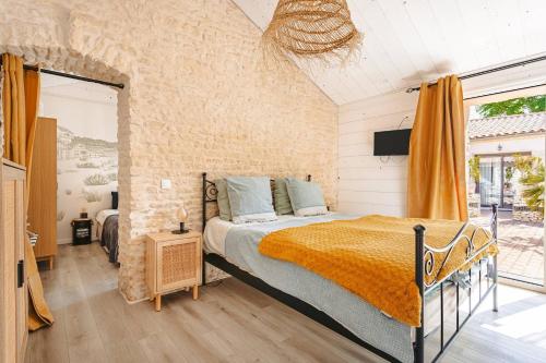 a bedroom with a bed and a tv in it at Domaine Roses Des Sables in La Jarrie