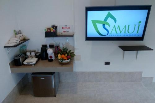 a tv hanging on a wall in a room at Samui Little Garden Resort in Chaweng