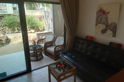 a living room with a black leather couch and chairs at Samui Little Garden Resort in Chaweng