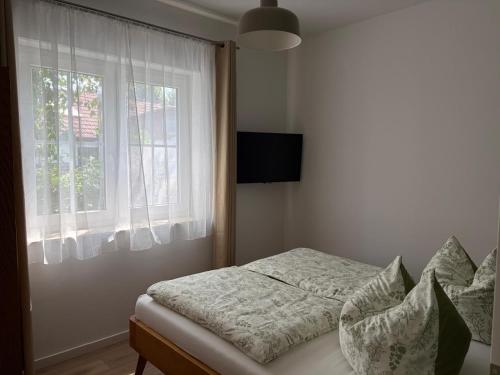 a bedroom with a bed with a window and a television at Ferienwohnung Forêt de la Sprée - Werben Spreewald in Werben