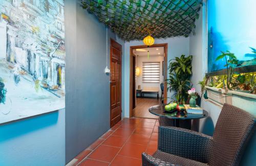 a hallway with a table and chairs and paintings at Golden Amour Hotel in Hanoi