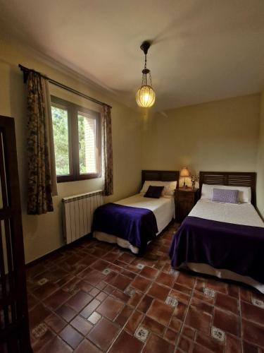 a bedroom with two beds and a window at LA CANTERICA in Fuentes de Rubielos
