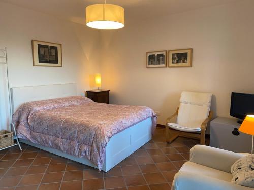 a bedroom with a bed and a chair and a couch at La Meridiana Apartment in Ghiffa