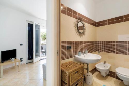 a bathroom with a sink and a toilet and a mirror at Casa Marea in Marzamemi