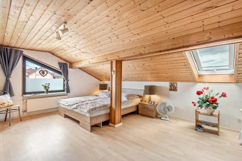 a bedroom with a bed and a wooden ceiling at Haus "Sonnenblume" in Regenstauf