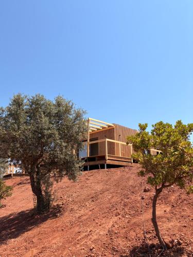 a house on the side of a hill with trees at wecamp Reserva Alecrim in Santiago do Cacém