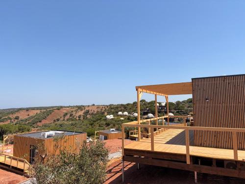 a building with a deck with a view of a mountain at wecamp Reserva Alecrim in Santiago do Cacém
