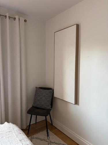 a black chair sitting in a bedroom next to a mirror at Birch House Ballina in Ballina
