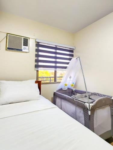 a bedroom with two beds and a window at 2BR Fully Air-Conditioned Staycation with Parking in Manila