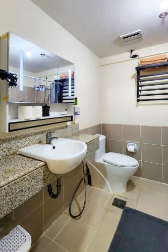 a bathroom with a white sink and a toilet at 2BR Fully Air-Conditioned Staycation with Parking in Manila