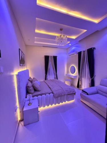a purple bedroom with a bed and a couch at EK Escape and Suites in Ado Ekiti