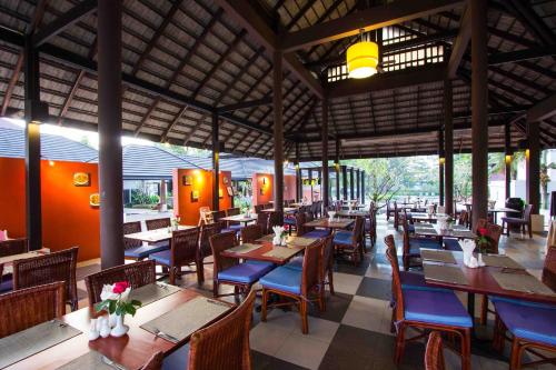 a restaurant with tables and chairs and a train at Palm Galleria Resort-SHA Extra Plus in Khao Lak