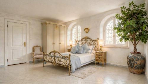ein Schlafzimmer mit einem Bett mit blauen Kissen und einer Pflanze in der Unterkunft Prima Stella in Positano