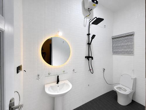 a bathroom with a toilet and a sink and a mirror at EK Escape and Suites in Ado Ekiti