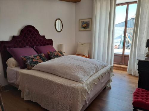 a bedroom with a large bed with a large window at la MORINNIERRE in Saint-Jean-de-Beugné