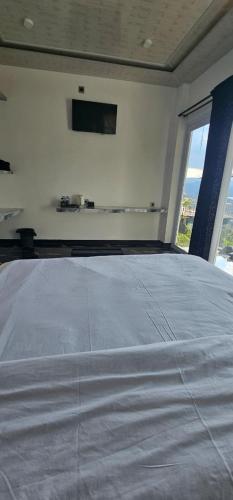 a bedroom with a large white bed with a window at Adelisca Glamping, Cafe and Villa in Kubupenlokan