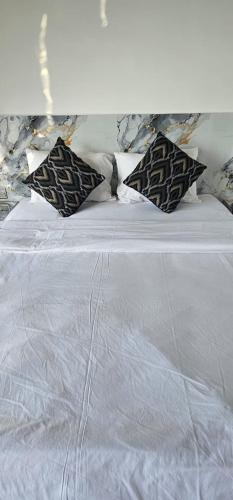 a white bed with three pillows on top of it at Adelisca Glamping, Cafe and Villa in Kubupenlokan
