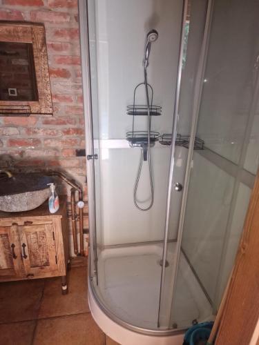 a shower with a glass door in a bathroom at Domki Brenna Leśnica chatka ze spa in Brenna