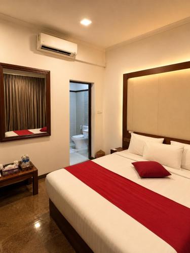 a bedroom with a large bed and a bathroom at Tarshish Villa - Colombo in Colombo
