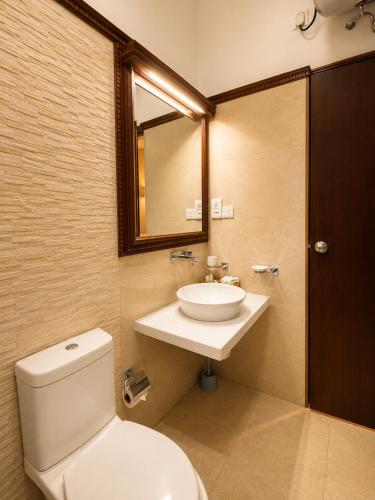 a bathroom with a toilet and a sink and a mirror at Tarshish Villa - Colombo in Colombo