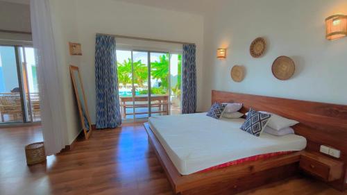 a bedroom with a bed and a view of the ocean at Verdana House in Kiwengwa