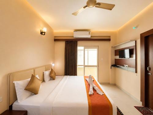 a hotel room with a bed with a stuffed animal on it at Hotel Golden Wave Puri - Baliapanda Housing Colony - Near Golden Beach- Parking - Restaurant in Puri