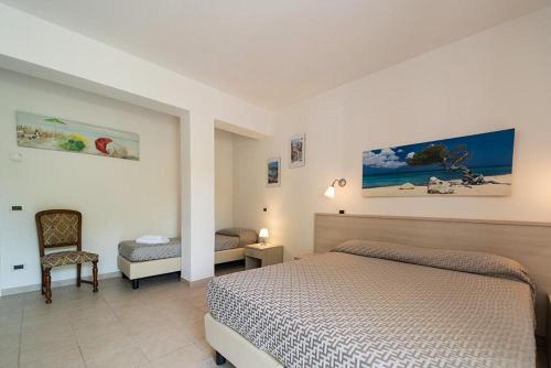 een slaapkamer met een bed en een stoel in een kamer bij Hotel Punta Pina in Portoferraio