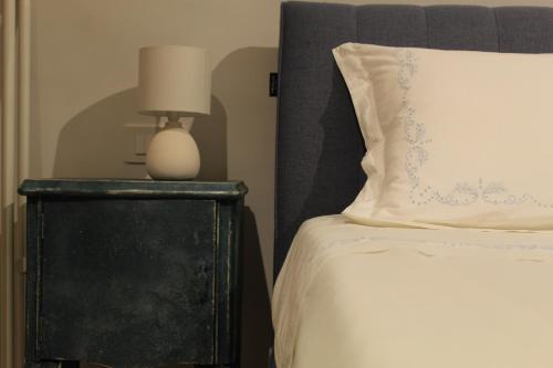 a bed with a white pillow and a lamp on a night stand at Le Casette della Murgia in Cassano delle Murge