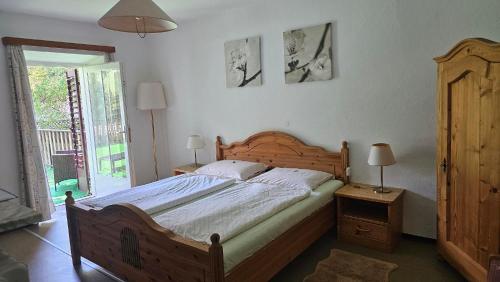a bedroom with a large wooden bed and two lamps at Manötscherhof in Tires