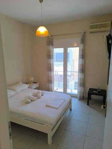 a bedroom with a bed and a large window at George apartment in Artemida